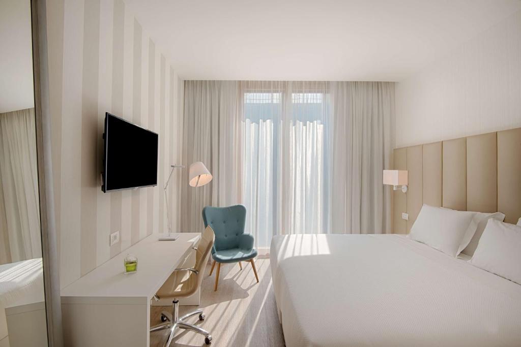A bed or beds in a room at NH Trento