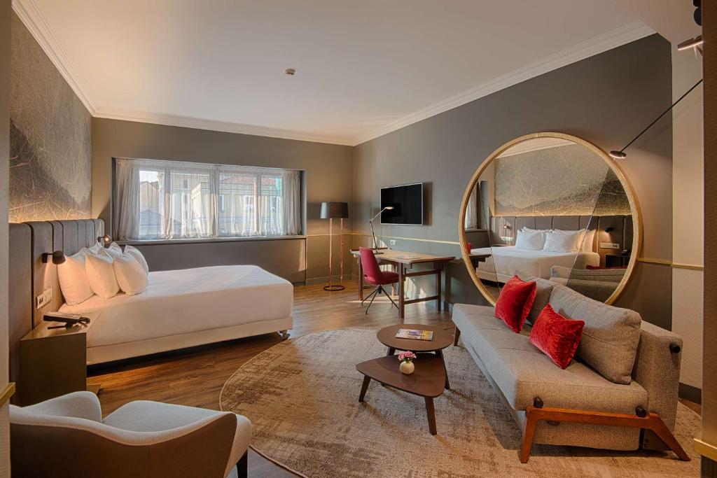 um quarto de hotel com uma cama e um espelho em NH Collection Porta Nuova em Milão