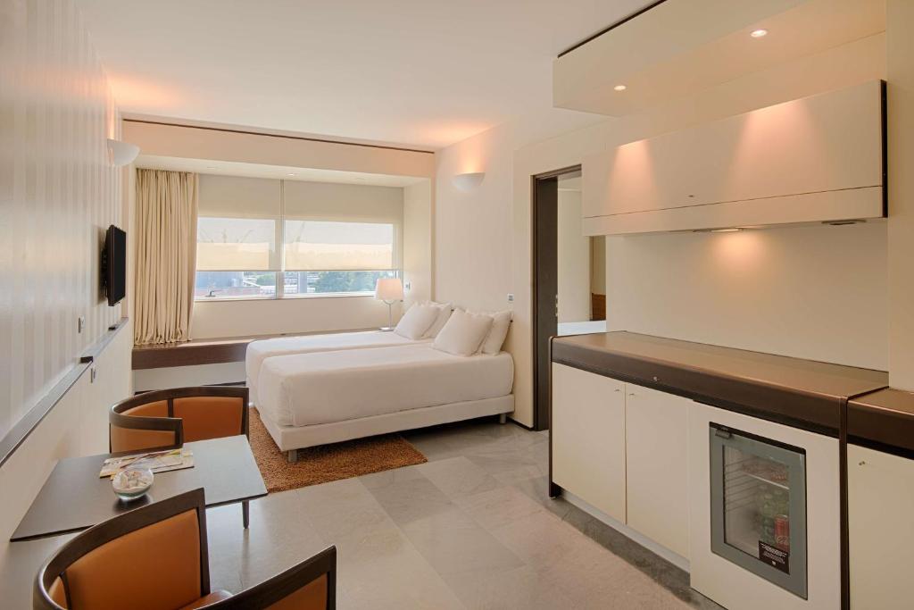 ein Wohnzimmer mit einem weißen Bett und eine Küche in der Unterkunft NH Venezia Laguna Palace in Mestre