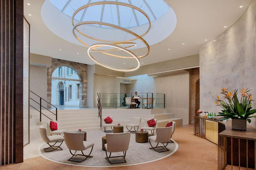 a lobby with a large chandelier in a building at NH Collection Palazzo Verona in Verona