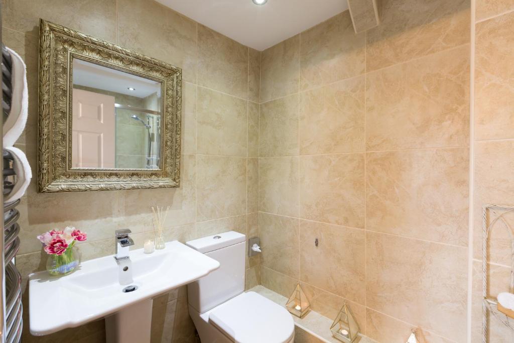 a bathroom with a toilet and a sink and a mirror at Warkworth House Hotel in Warkworth