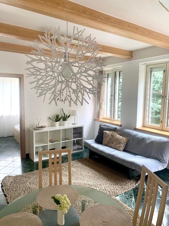 a living room with a couch and a chandelier at Zidinio Liepsnele in Palanga