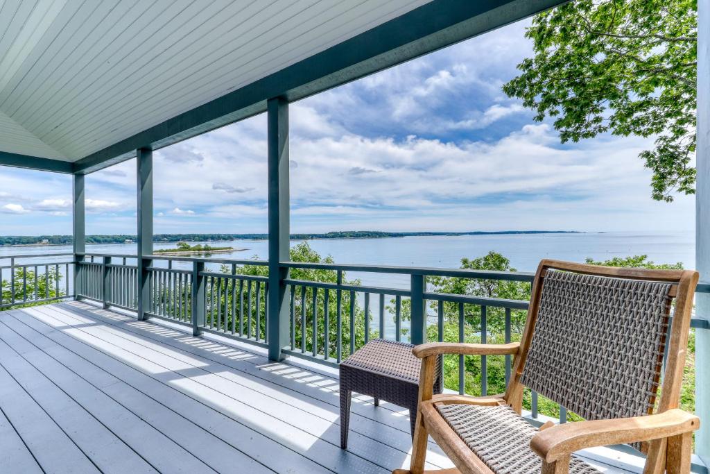 a deck with two chairs and a view of the water at Fanta Sea Shores in Wiscasset