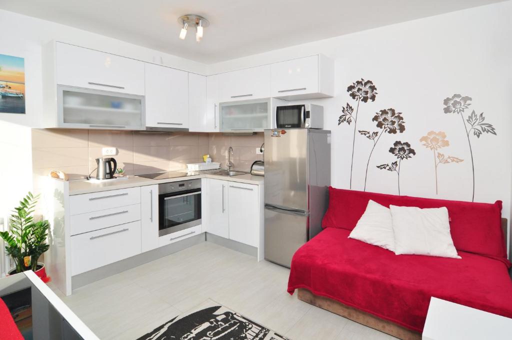 uma sala de estar com um sofá vermelho numa cozinha em Full equipped flat close to all em Split