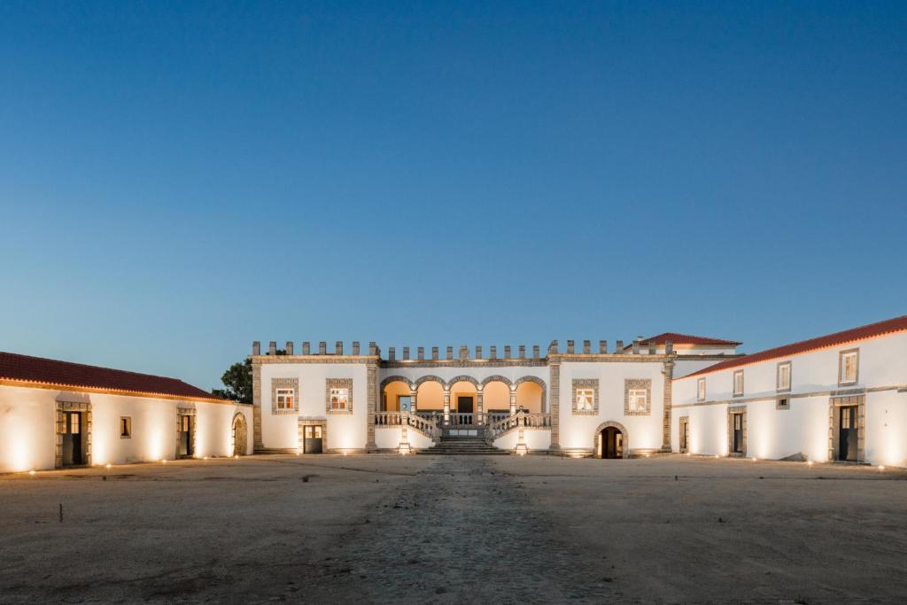 een lege binnenplaats van een groot wit gebouw bij Hotel Paço de Vitorino in Ponte de Lima