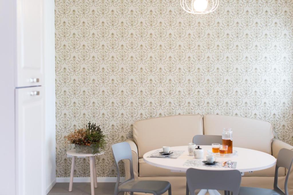 a dining room with a table and chairs and a wall with wallpaper at Venezia Fly Apartments in Tessera