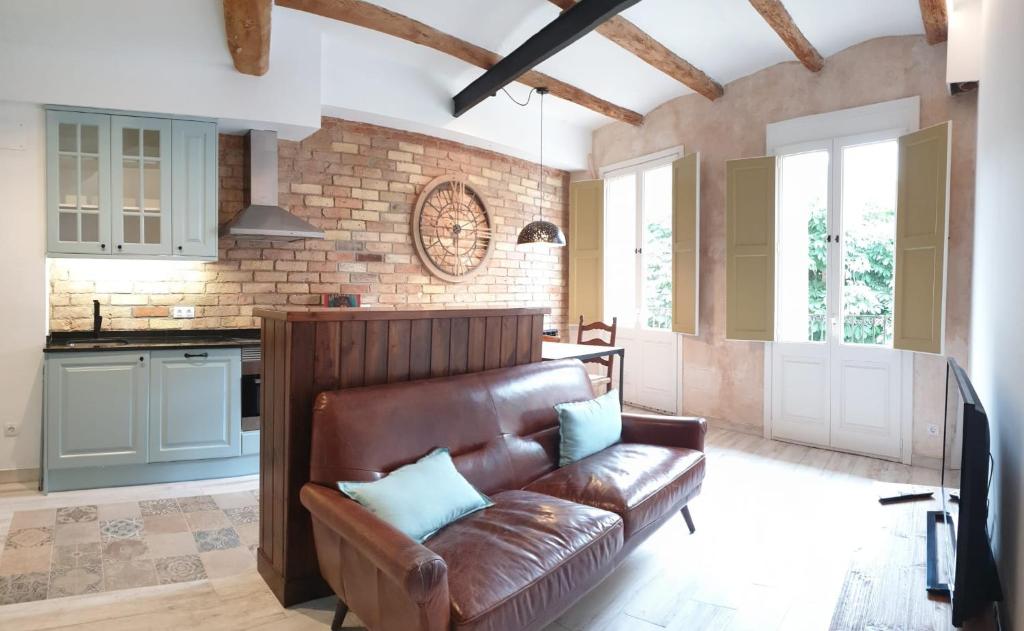 a living room with a leather couch in a kitchen at Casa Filomena apartamento de diseño en St. Joan de les Abadesses in Sant Joan de les Abadesses