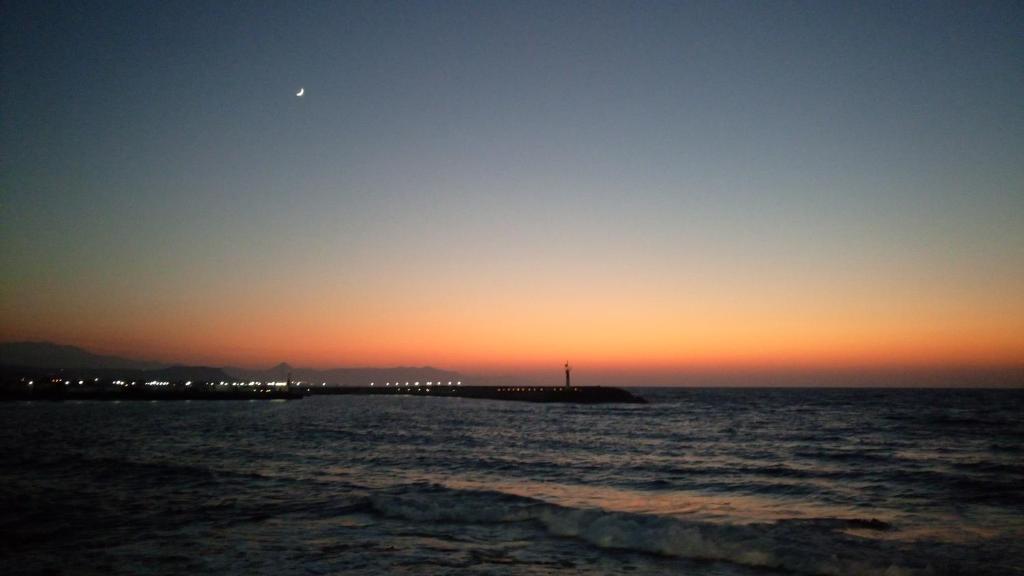 vista sull'oceano al tramonto con molo di Anfi Suites a Gouves