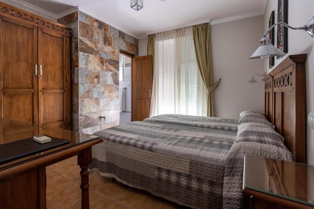 1 dormitorio con 1 cama y escritorio en una habitación en Hostal Costa Luz, en El Puerto de Santa María