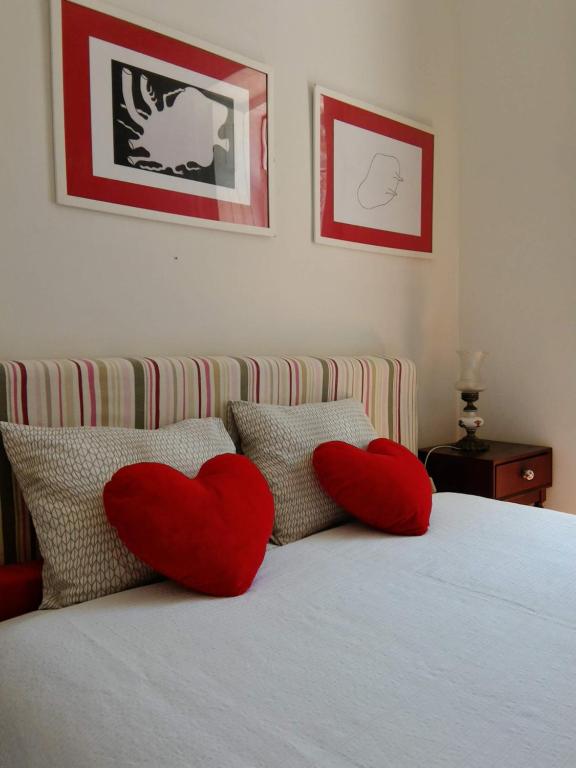 Dois corações vermelhos estão sentados numa cama em Guest House VC17 em Sintra