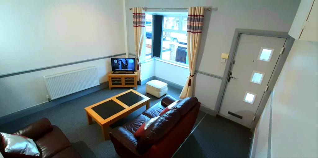 ein Wohnzimmer mit einem Sofa und einem TV in der Unterkunft Grimsby-Cleethorpes Sleeps 7 in Grimsby