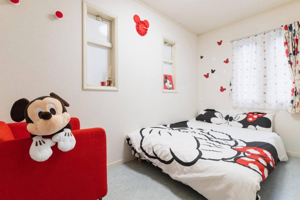 a bedroom with a red chair and a mickey mouse bedroom at City Garden - Vacation STAY 87278 in Fukuoka