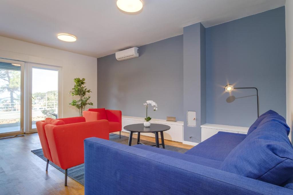 a living room with a blue couch and red chairs at Dea2 in Mali Lošinj