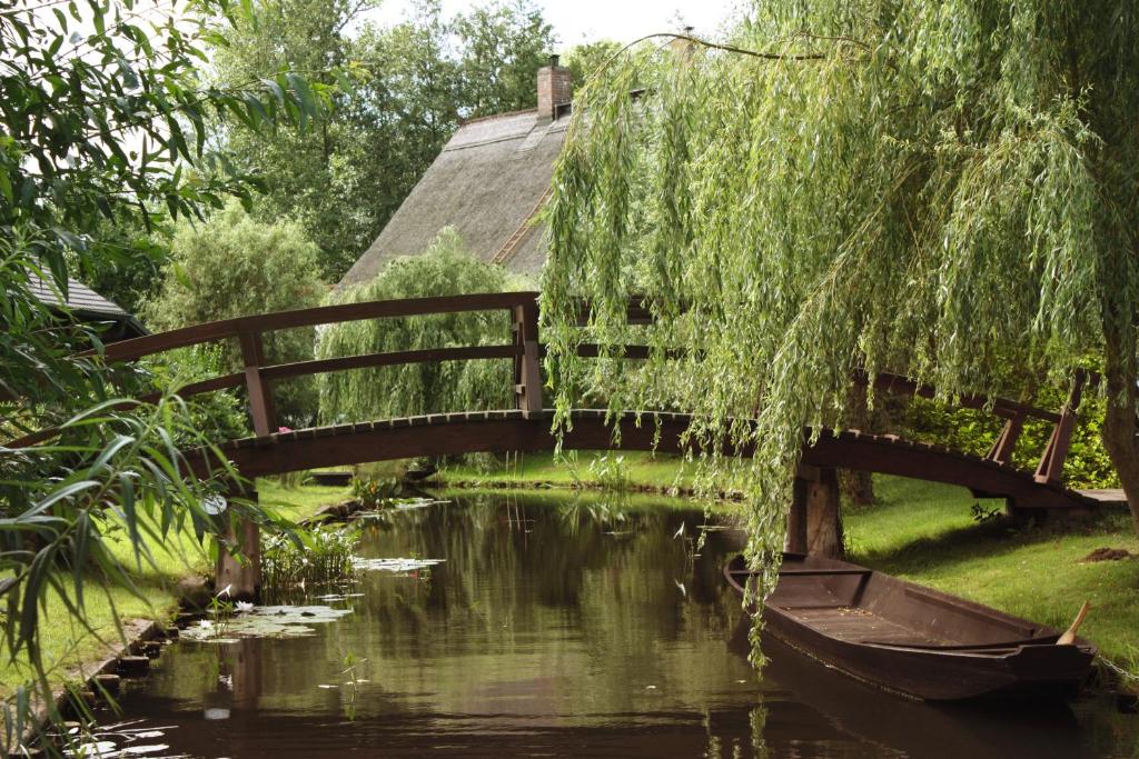 a bridge over a river with a boat at Hotelanlage Starick in Lübbenau