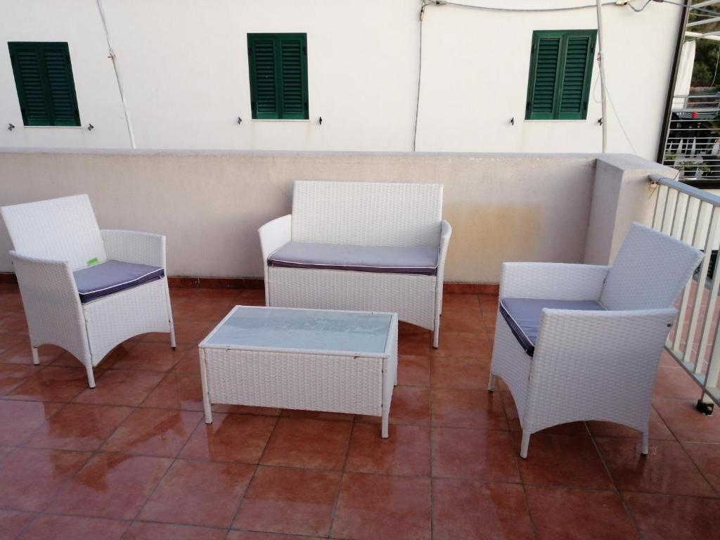 a group of chairs and tables on a balcony at Casa Maris in Santo Stefano di Camastra