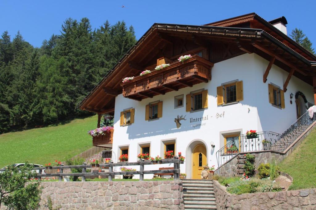 uma casa branca com um telhado castanho em Untertalhof em Castelrotto