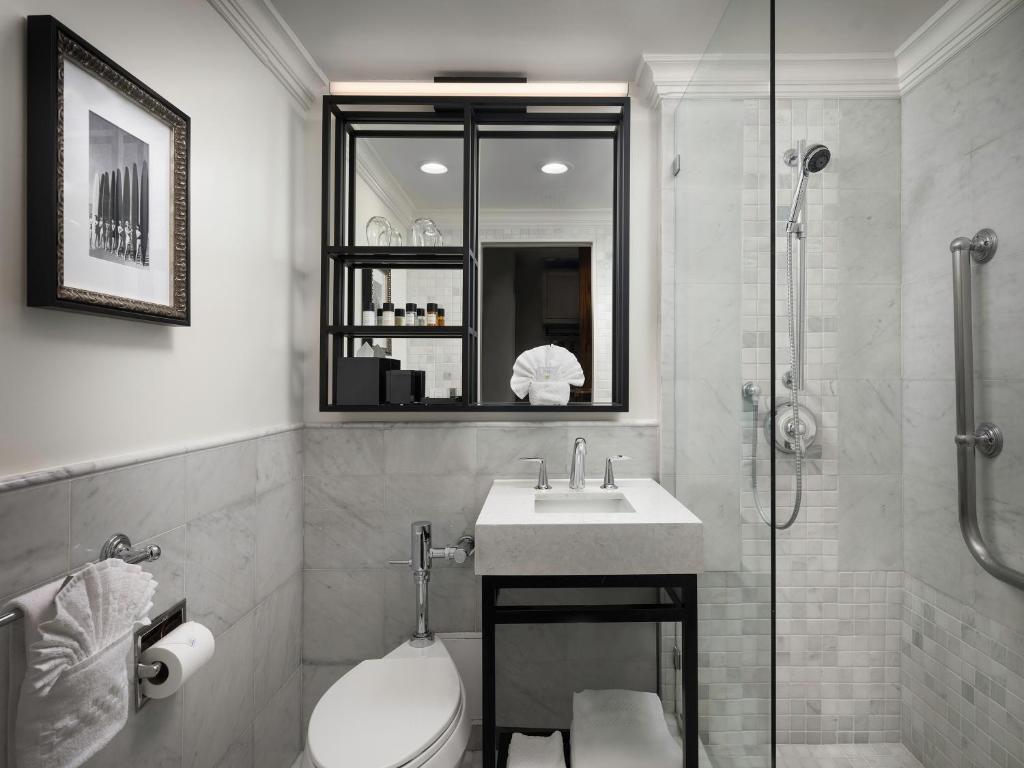 a bathroom with a toilet and a sink and a shower at La Valencia Hotel in San Diego
