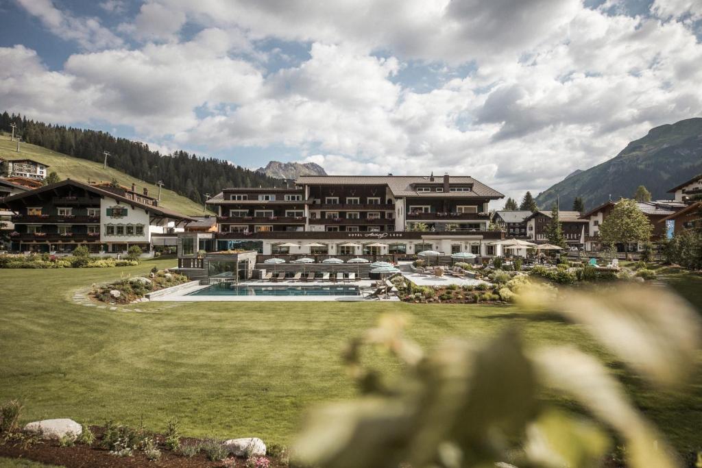 a resort with a large building and a swimming pool at Hotel Arlberg Lech in Lech am Arlberg