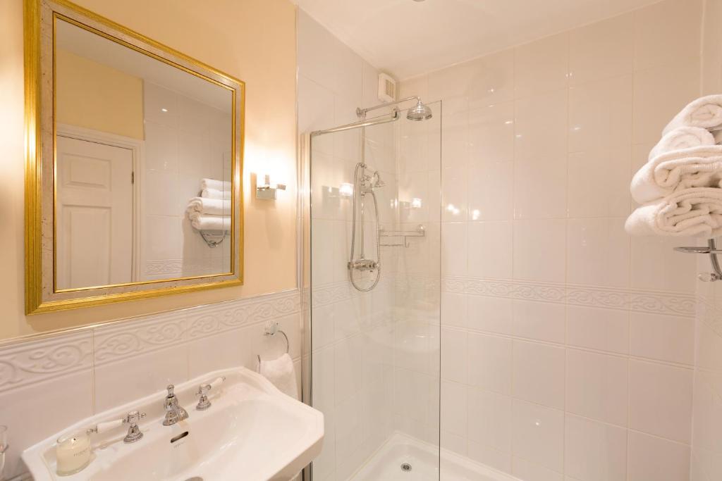a bathroom with a sink and a shower with a mirror at Warkworth House Hotel in Warkworth