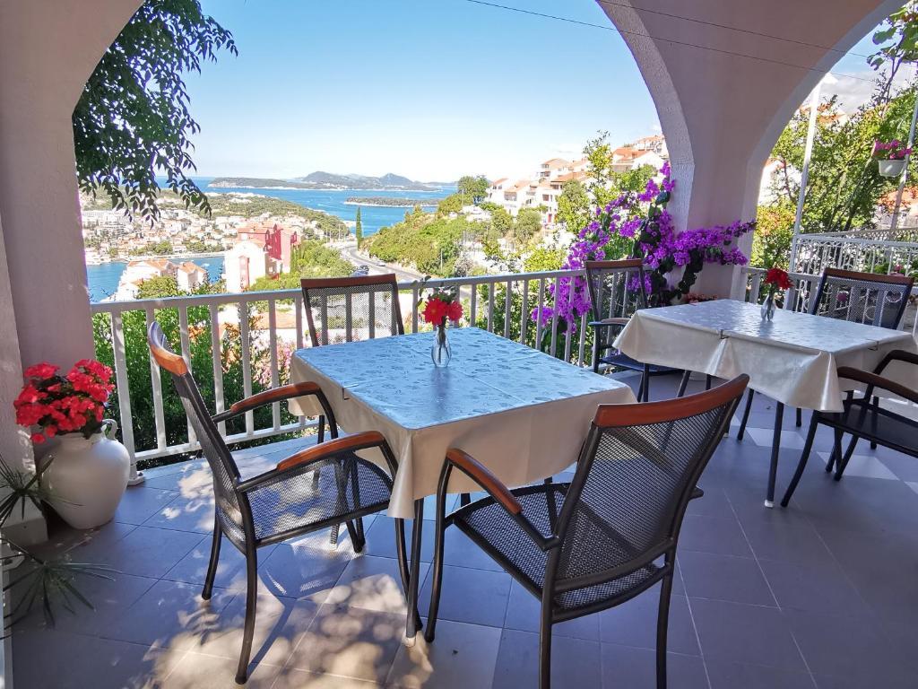 two tables and chairs on a balcony with a view of the ocean at House Smajić in Dubrovnik