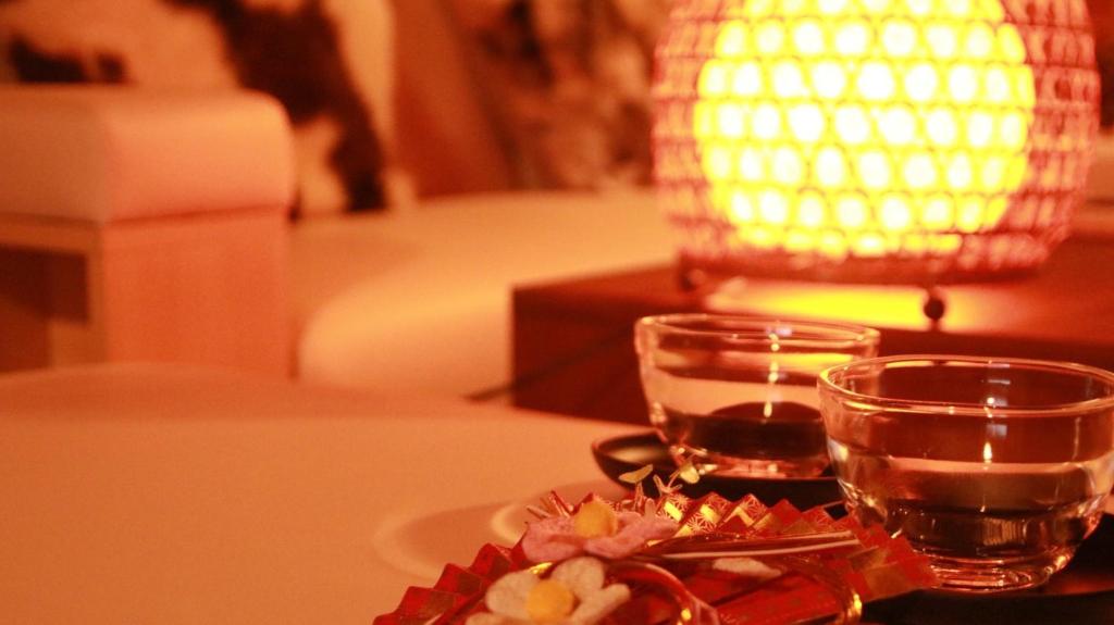 una mesa con un vaso de agua y un plato con flores en Nagoya - House - Vacation STAY 7563, en Nagoya