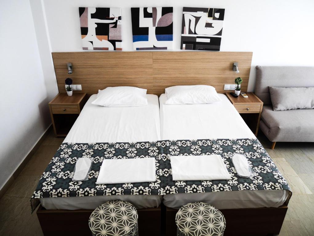 1 dormitorio con 1 cama con manta blanca y negra en Georgia, en Palaiochóra