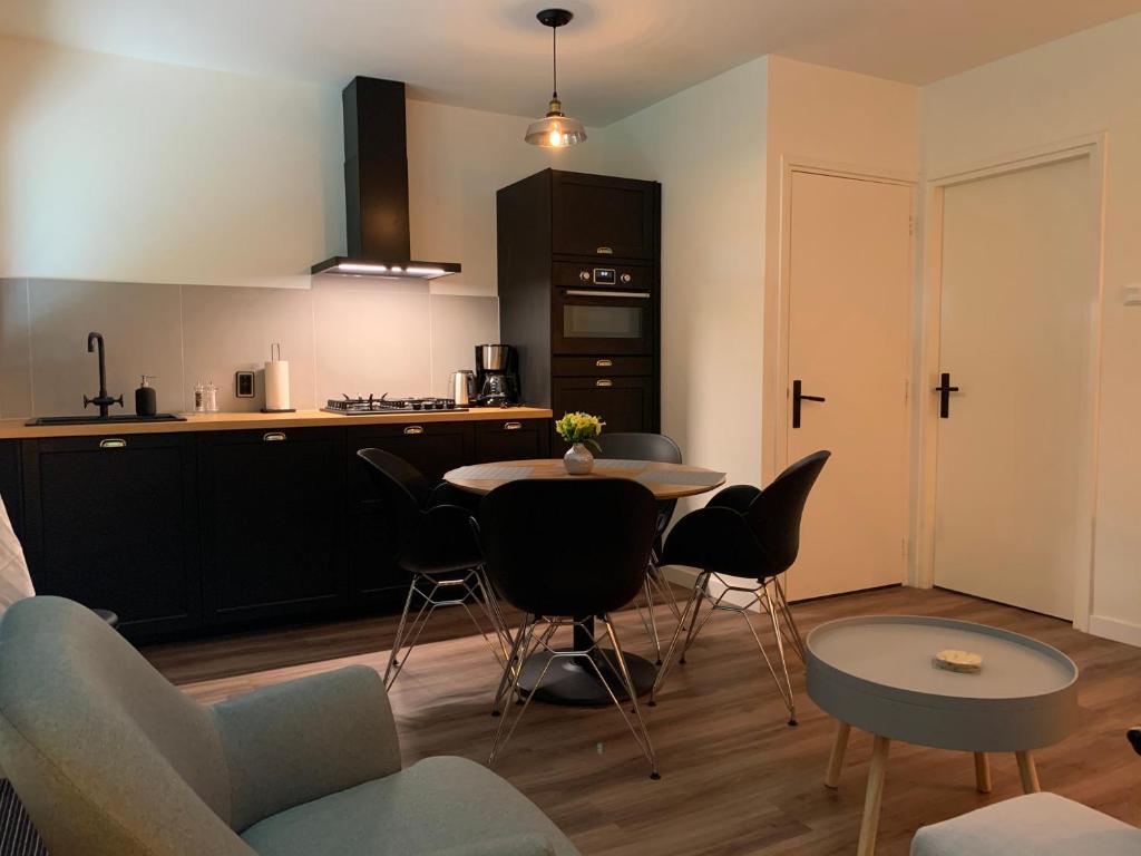 cocina con mesa y sillas en una habitación en De Wollige Hooglander: in comfort middenin natuur en Otterlo