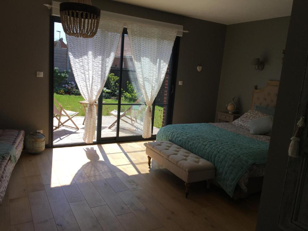 ein Schlafzimmer mit einem Bett und einem großen Fenster in der Unterkunft Au gré des saisons in Héricourt