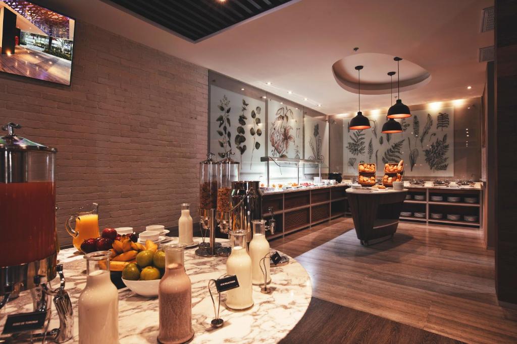 A buffet service area with fruit, beverages, pastries and plated food.