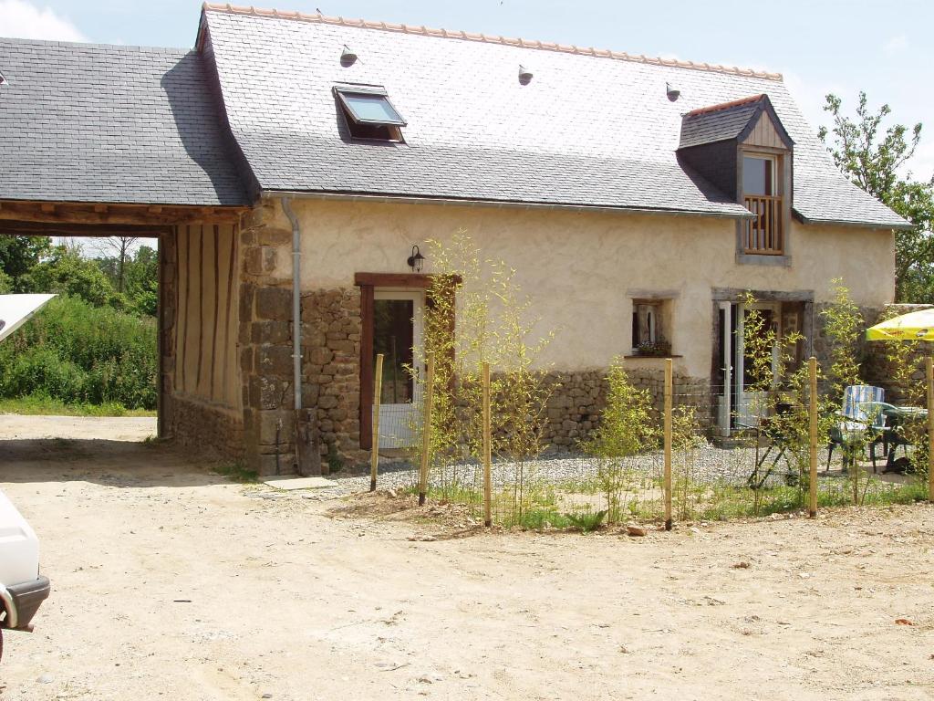 une maison avec une clôture devant elle dans l'établissement Gîte de La Porte du Parc, à Les Iffs