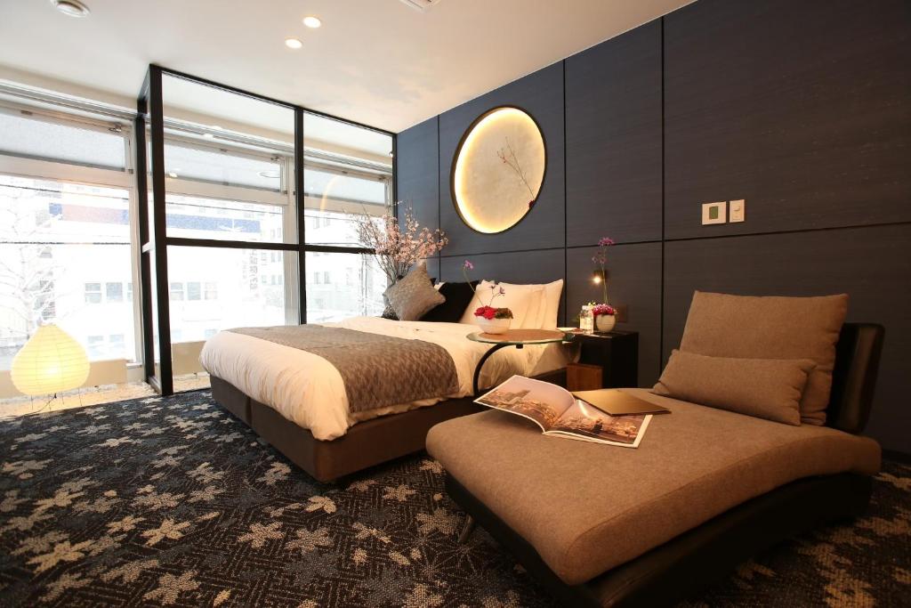 a bedroom with two beds and a table and a couch at 2nd floor of 3rd NEO building - Vacation STAY 88300 in Sapporo
