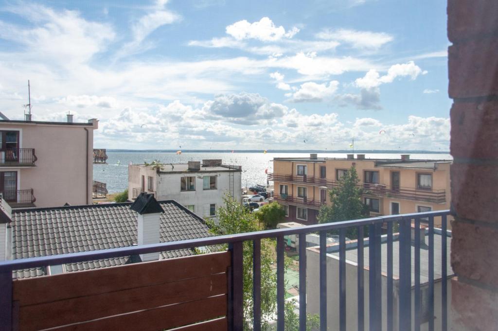 een balkon met uitzicht op de oceaan en gebouwen bij Villa Baltic Chałupy - Apartament nr 14A in Chałupy