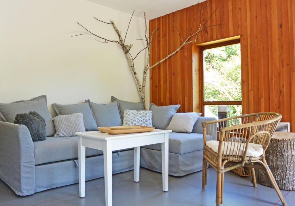 een woonkamer met een bank en een tafel en stoelen bij Chalet Cosy Nature in Alzon