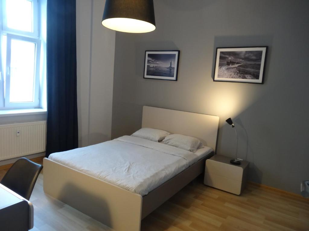 ein Schlafzimmer mit einem weißen Bett und einer Lampe in der Unterkunft One More Night Apartment, Poznan Old Town in Posen