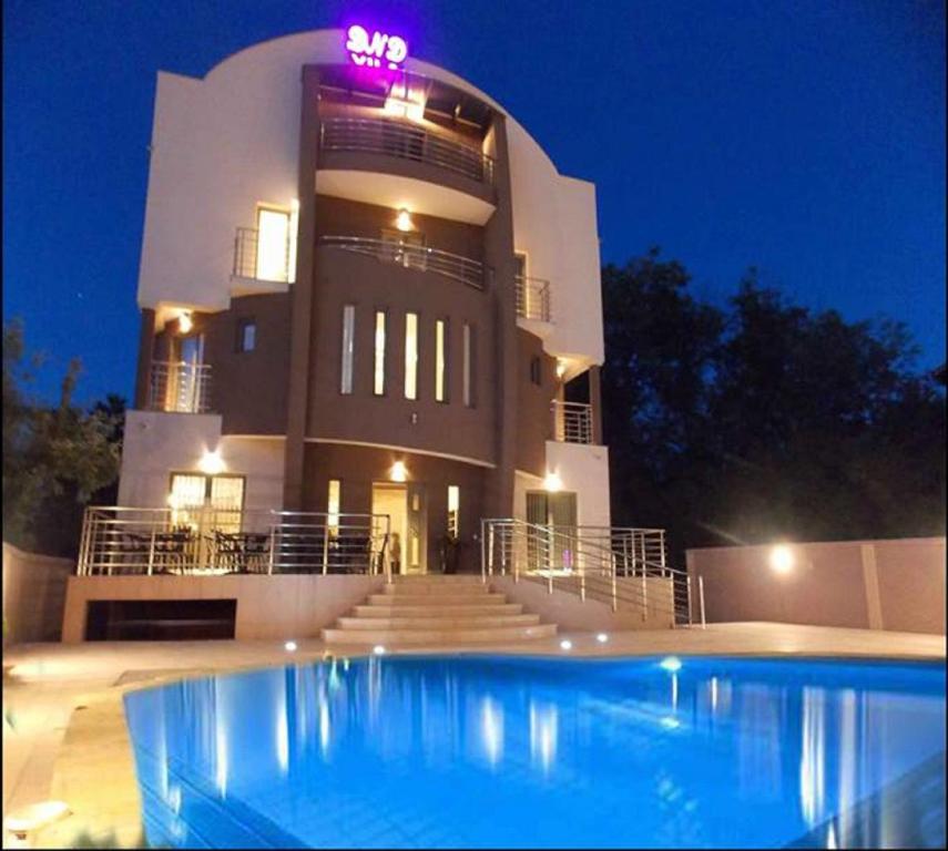 un gran edificio con una piscina frente a él en Guesthouse Vila DND, en Niška Banja