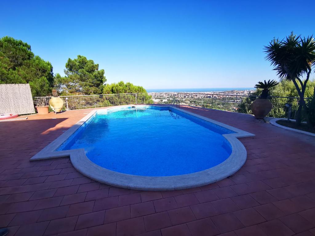 uma grande piscina azul num pátio de tijolos em Holiday flower villa panoramica sul golfo di Catania em Misterbianco