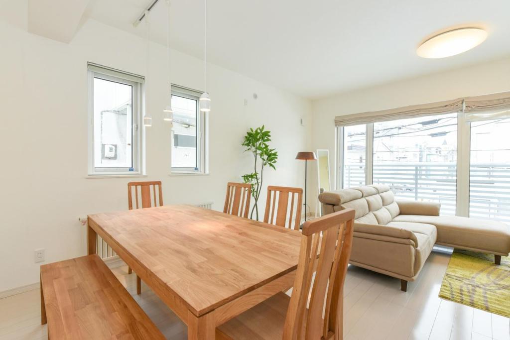 ein Wohnzimmer mit einem Holztisch und einem Sofa in der Unterkunft Private House S12 - Vacation STAY 87118 in Sapporo