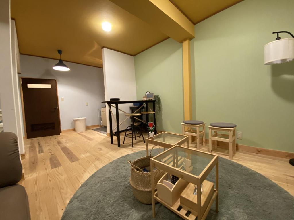 a living room with a table and some chairs at mooi guesthouse 日新町 in Aizuwakamatsu