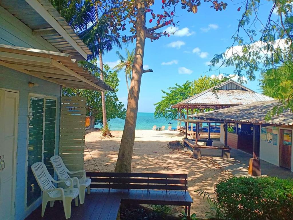 eine Veranda eines Hauses mit einer Bank und einem Strand in der Unterkunft Patoo in Ko Chang