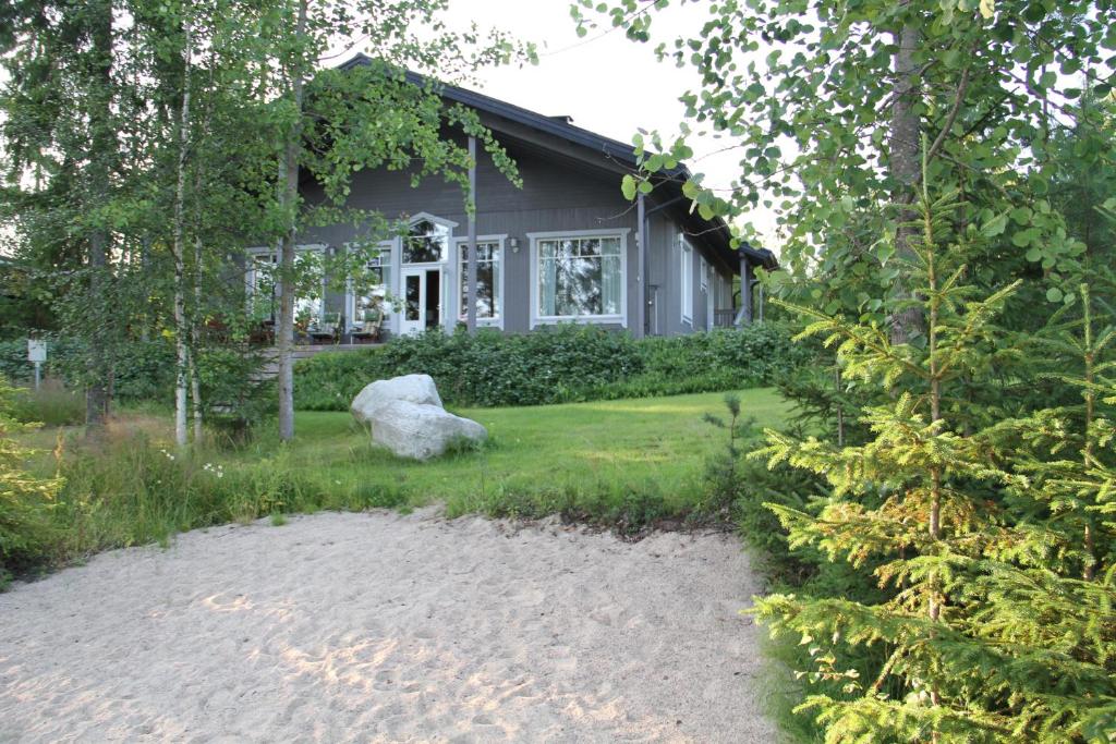 una casa con una roca delante de ella en Miiluranta Villas, en Haapamäki