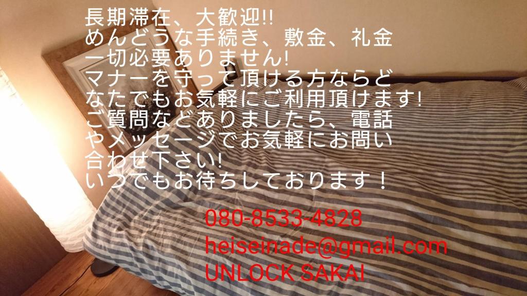 una cama con escritura china a un lado. en UNLOCK SAKAI en Sakai