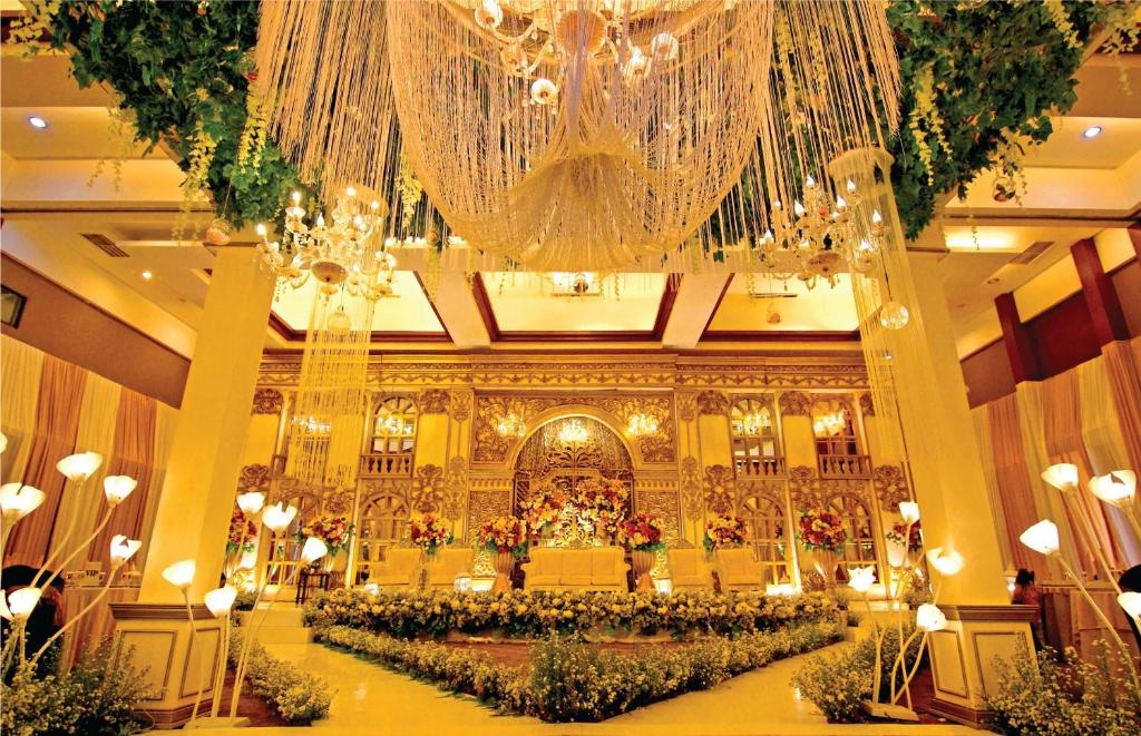 Hermes Palace Hotel Banda Aceh في باندا أسيه: غرفة كبيرة وثريا كبيرة في مبنى