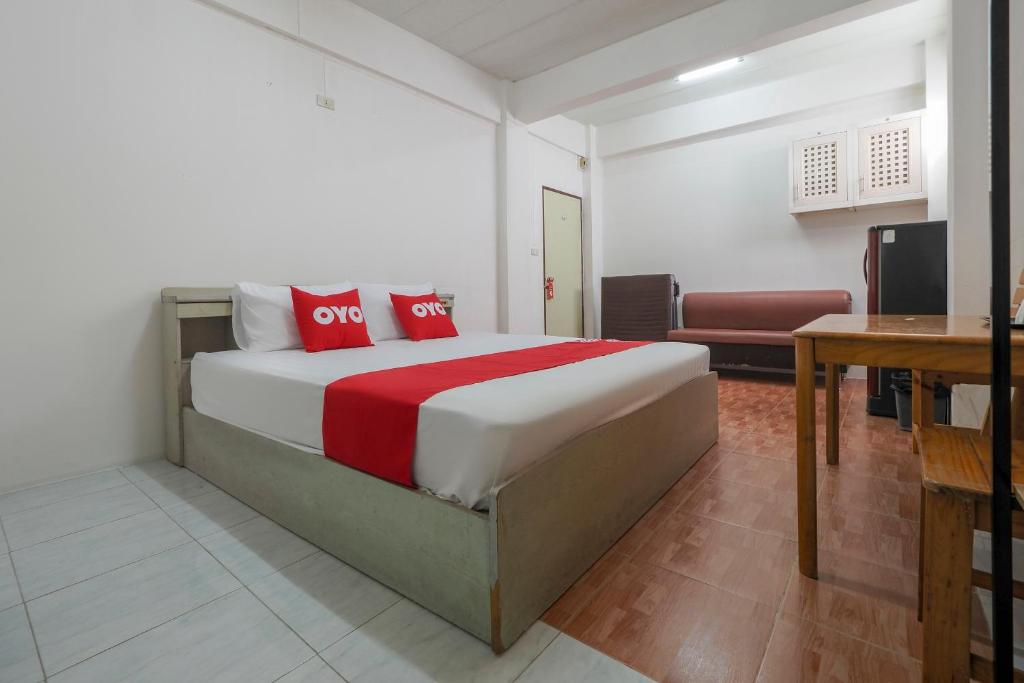 una camera con letto, scrivania e TV di OYO 471 Sunshine Apartment a Bangkok