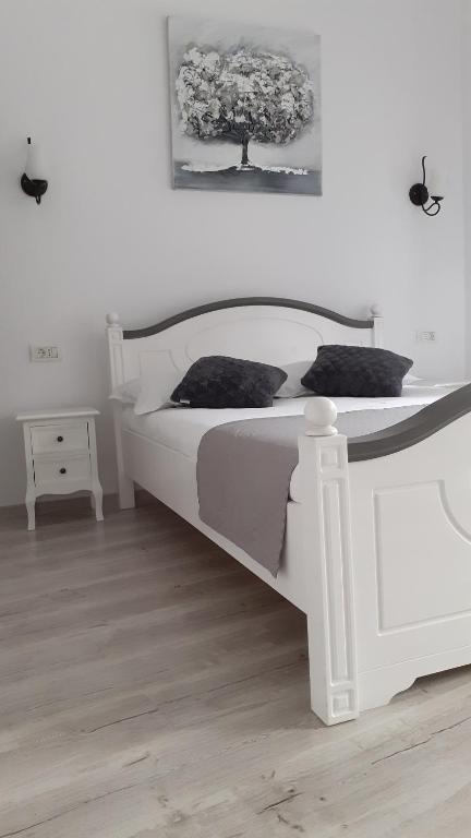 ein Schlafzimmer mit einem weißen Bett mit einem Baum an der Wand in der Unterkunft Casa Bella in Sibiu