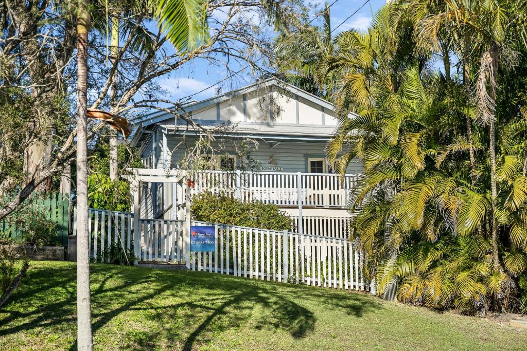 a white fence in front of a white house at Kembali on Massinger Street in Byron Bay