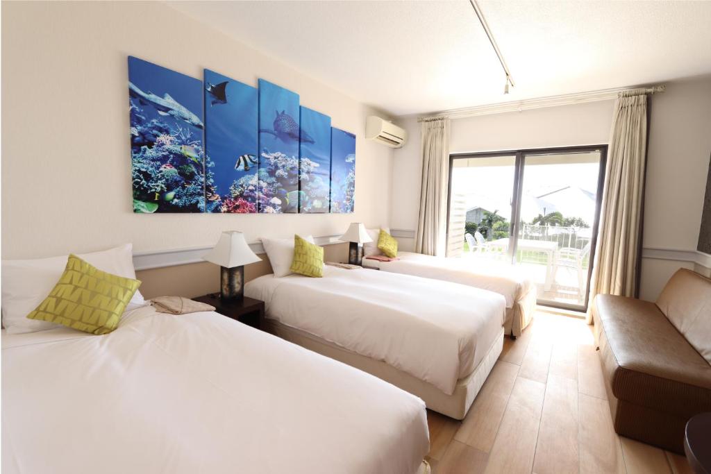 a hotel room with three beds and a couch at Royal View Hotel Churaumi in Motobu