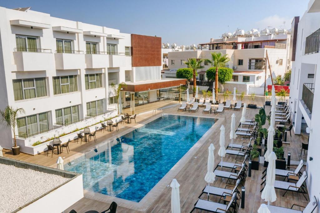 an overhead view of a hotel pool with chairs and tables at Cosmo Napa Boutique Hotel in Ayia Napa