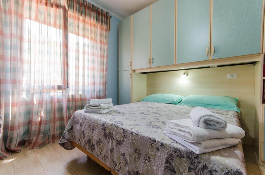 sypialnia z łóżkiem z ręcznikami w obiekcie Vacanze a Loceri w mieście Loceri