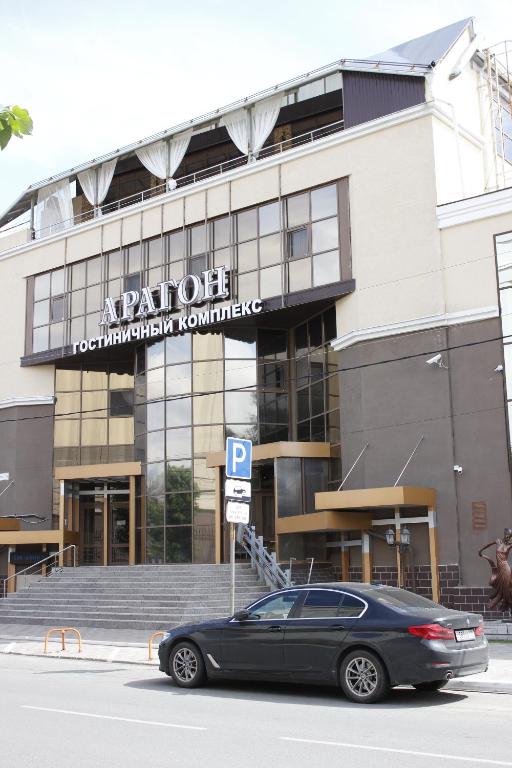 a black car parked in front of a building at Aragon Hotel in Ryazan