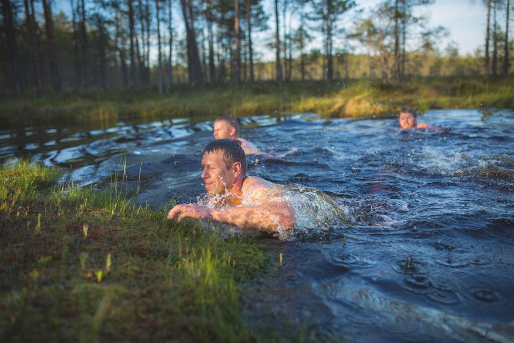 three children swimming in a river in the woods at Tuhamäe hosteli puhkemaja in Kiviõli